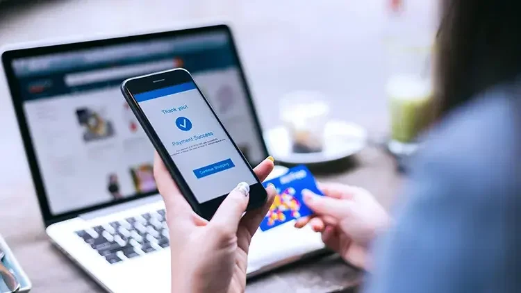 A woman holds her phone while making an online purchase. Though ecommerce was introduced nearly 30 years ago, it continues to evolve at hyperspeed.