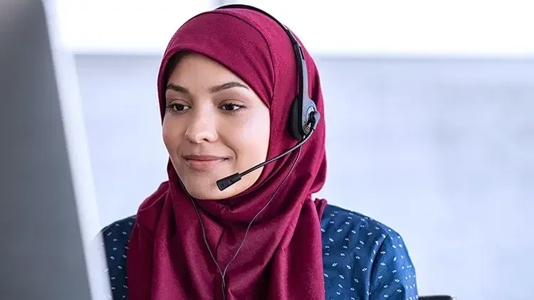 woman-wearing-headset-smiles-looking-at-monitor 1