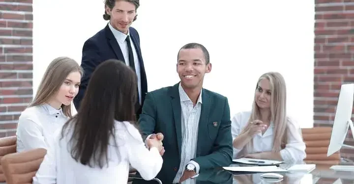 Coworkers in an office shaking hands