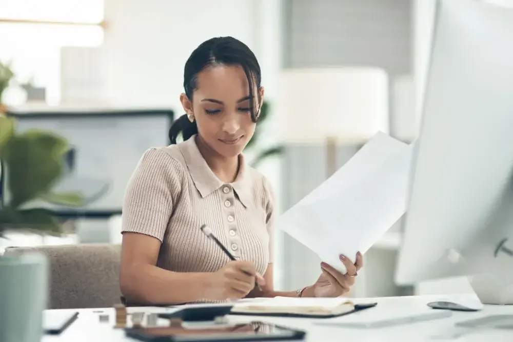 A woman makes notes on her tax return before putting it in storage in safe, dry place.