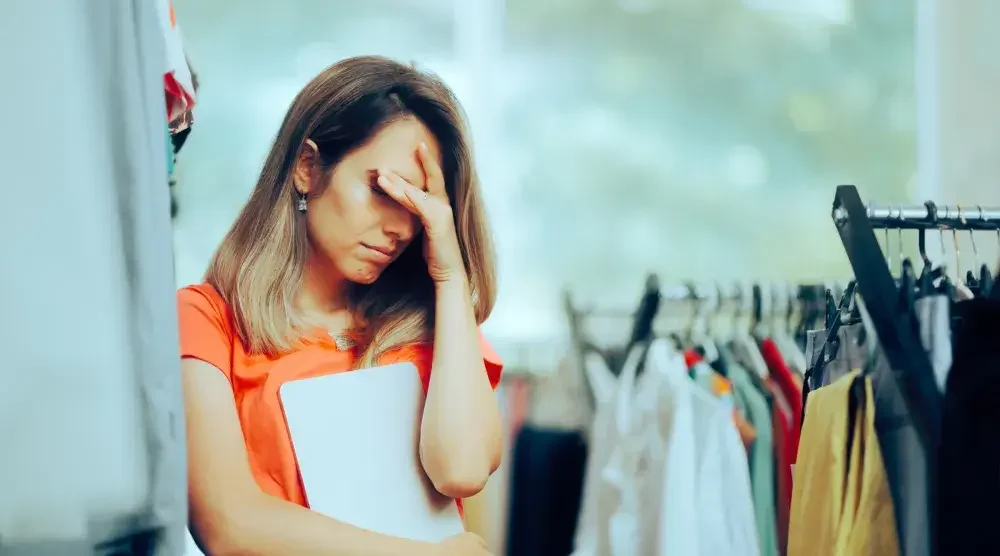 The owner of a cA clothing store owner stands near her inventory and puts her hand over her face in grief as she contemplates bankruptcy. Bankruptcy attorneys can help you identify assets and find a way to assist you in protecting key pieces of your business. 