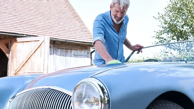 Senior man polishes car