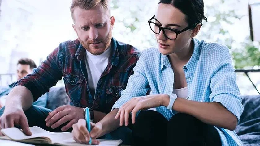 man-woman-look-overnotes-writing