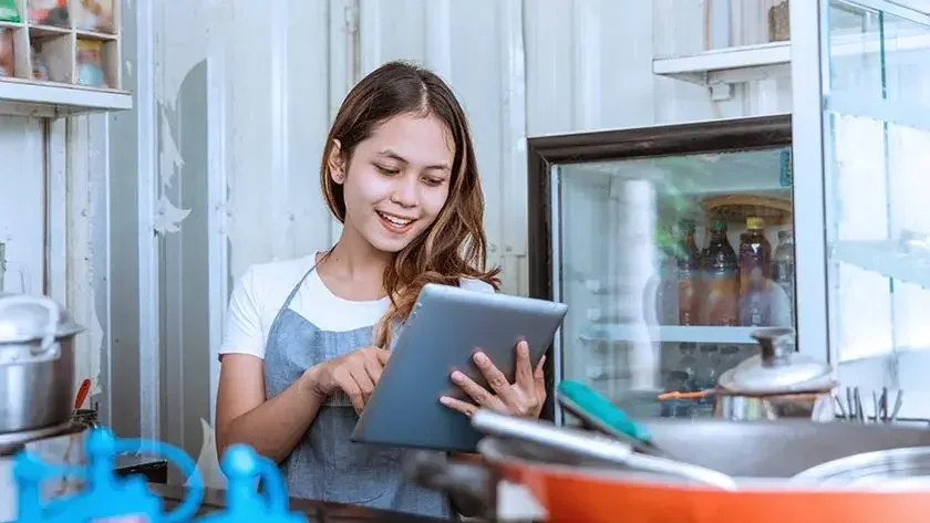 woman-smiling-using-tablet-restaurant