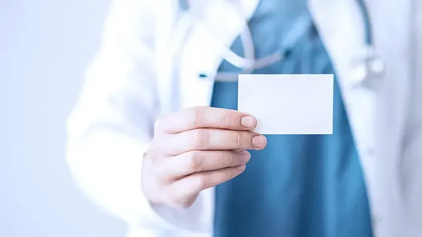 A doctor holds a vaccination card that is issued to patients after they get their shot.