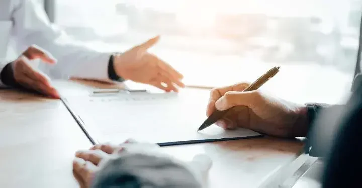 Person presenting documents to another person who is signing them