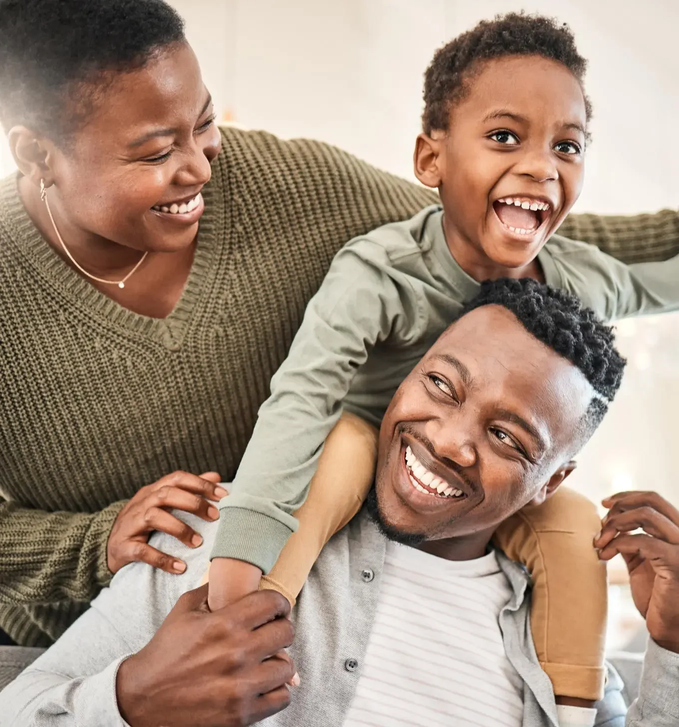 A family of three who is laughing and smiling.