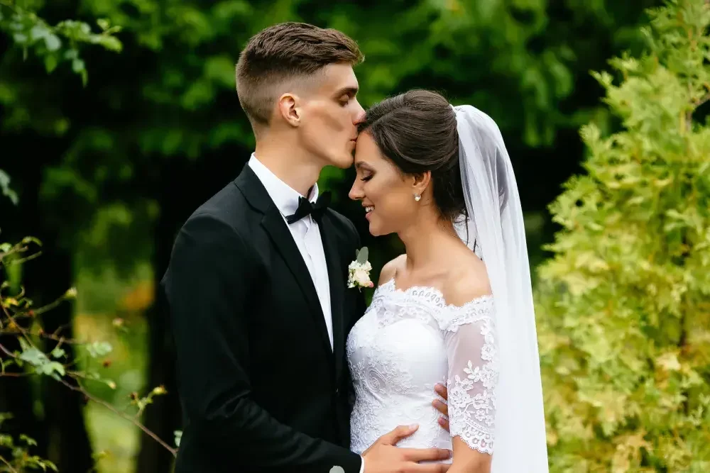 A man and woman in traditional dress attire share a kiss. A prenup can address a variety of topics, including financial responsibilities and spousal rights.