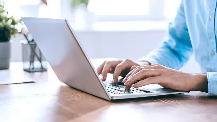 woman hands typing on laptop