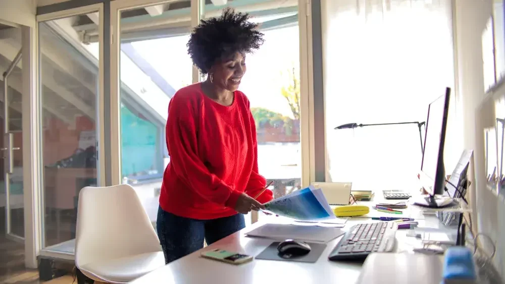 A woman organizes documents after learning her home-based business is being audited.