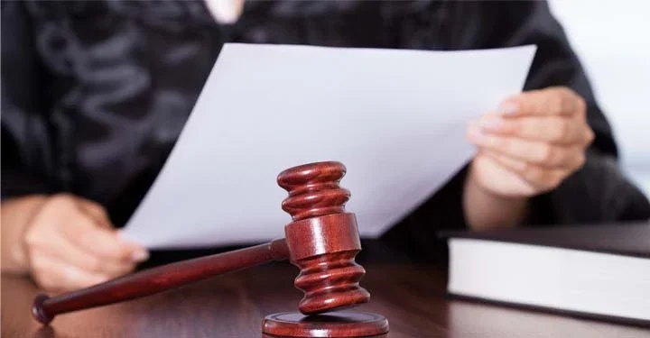 A zoomed-in image of a judge reviewing paperwork at an emergency custody hearing