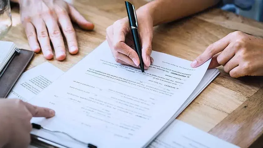 Woman and man signing contracts with attorney