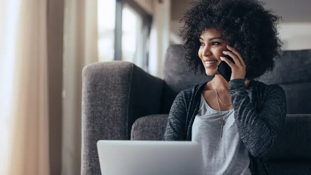 woman in grey sweater talking on cell phone 