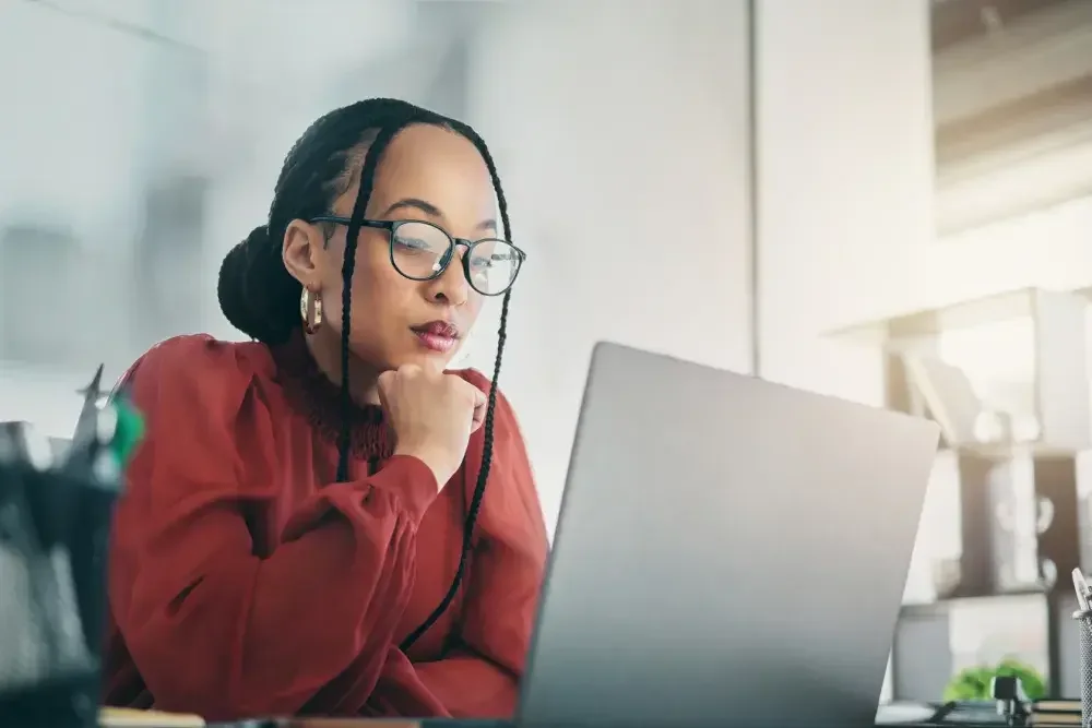 A small business owner looks over her business and income transactions on her laptop as she prepares for tax season.