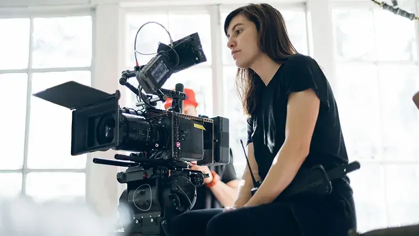 woman sitting behind a camera on a movie set