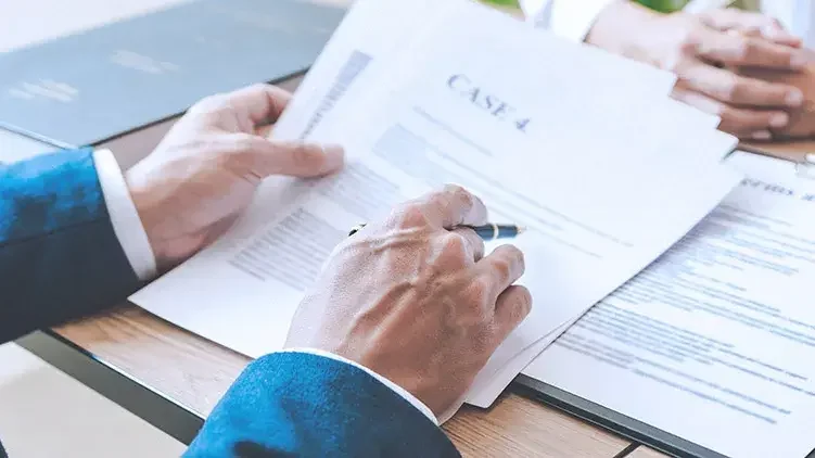 Man in suit reviews case paperwork with client