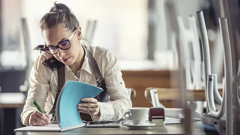 woman wearing an apron doing the books after hours 