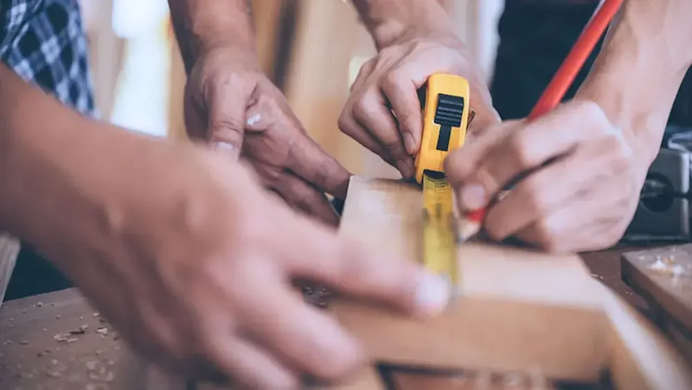 Two people use a measuring tape on a piece of wood for their carpentry business. Florida does not require your LLC to file an operating agreement, but it is an essential business component. 