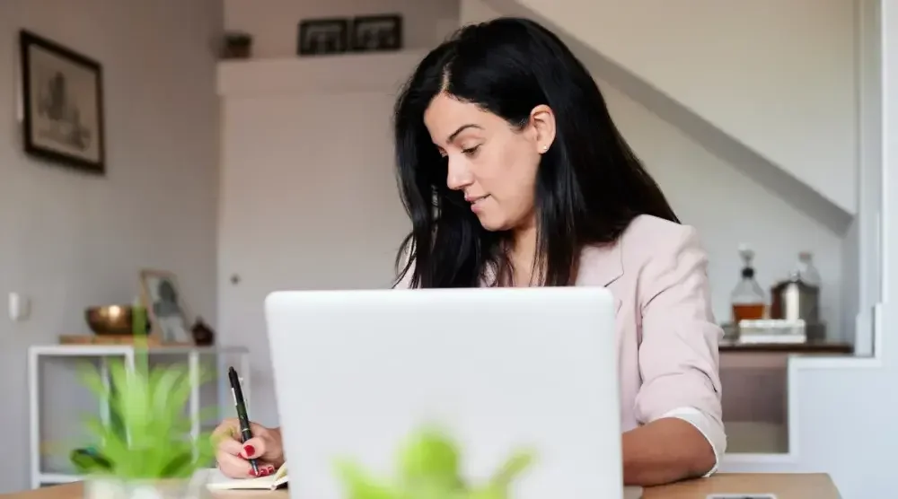 A woman seated at a desk in her home office in Alabama applies online for a business license. All companies and people engaged in business in the state of Alabama are required to apply for and keep up-to-date “privilege licenses.” 