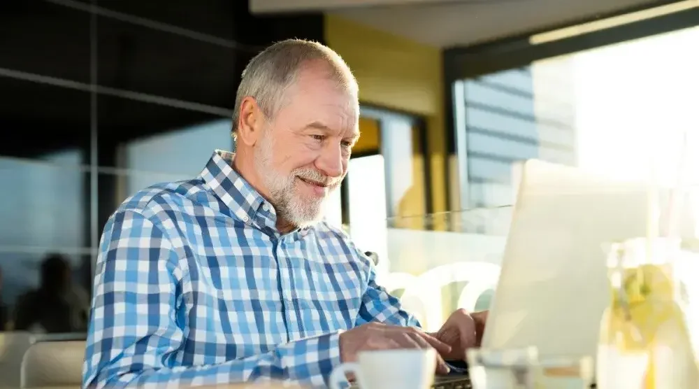 A business owner sits at a desk and conducts a Tennessee business search on his laptop.