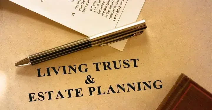 Paper labeled "Living Trust and Estate Planning" and a pen on top