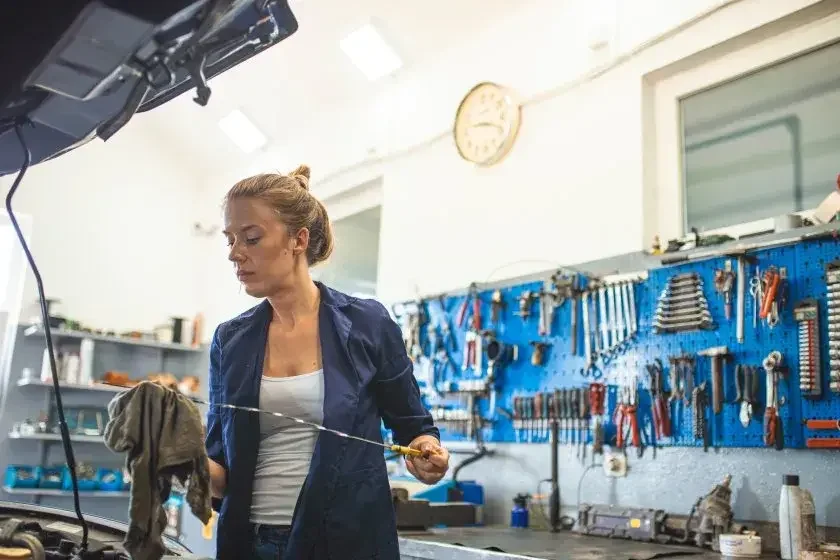 Most small business owners benefit from forming an LLC in their home state, such as this mechanic checking the oil on a car engine.