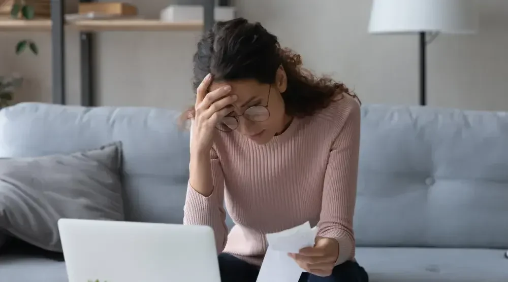 A woman carefully reads over papers. When filing for bankruptcy, it's important to understand and thoroughly consider your options.