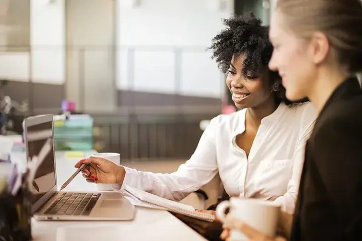 Two business people looking at a laptop together